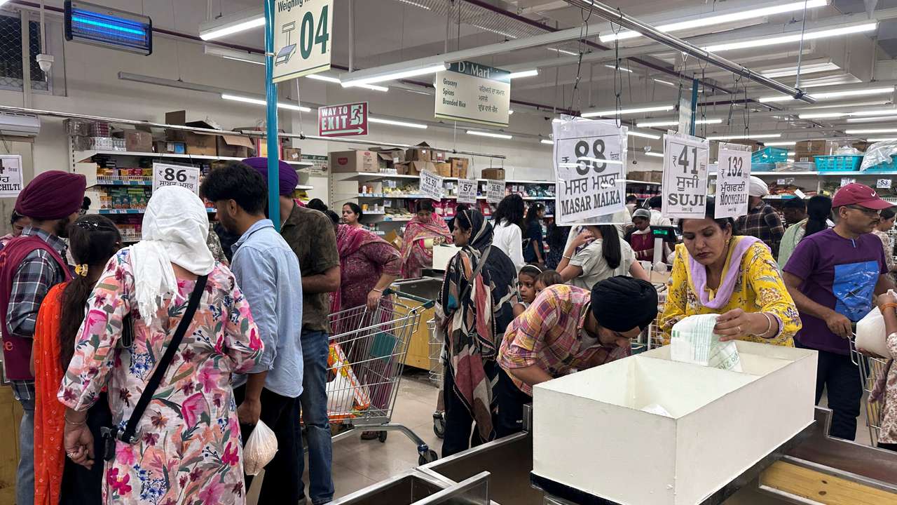 People shop for essential goods at a supermarket in Amritsar