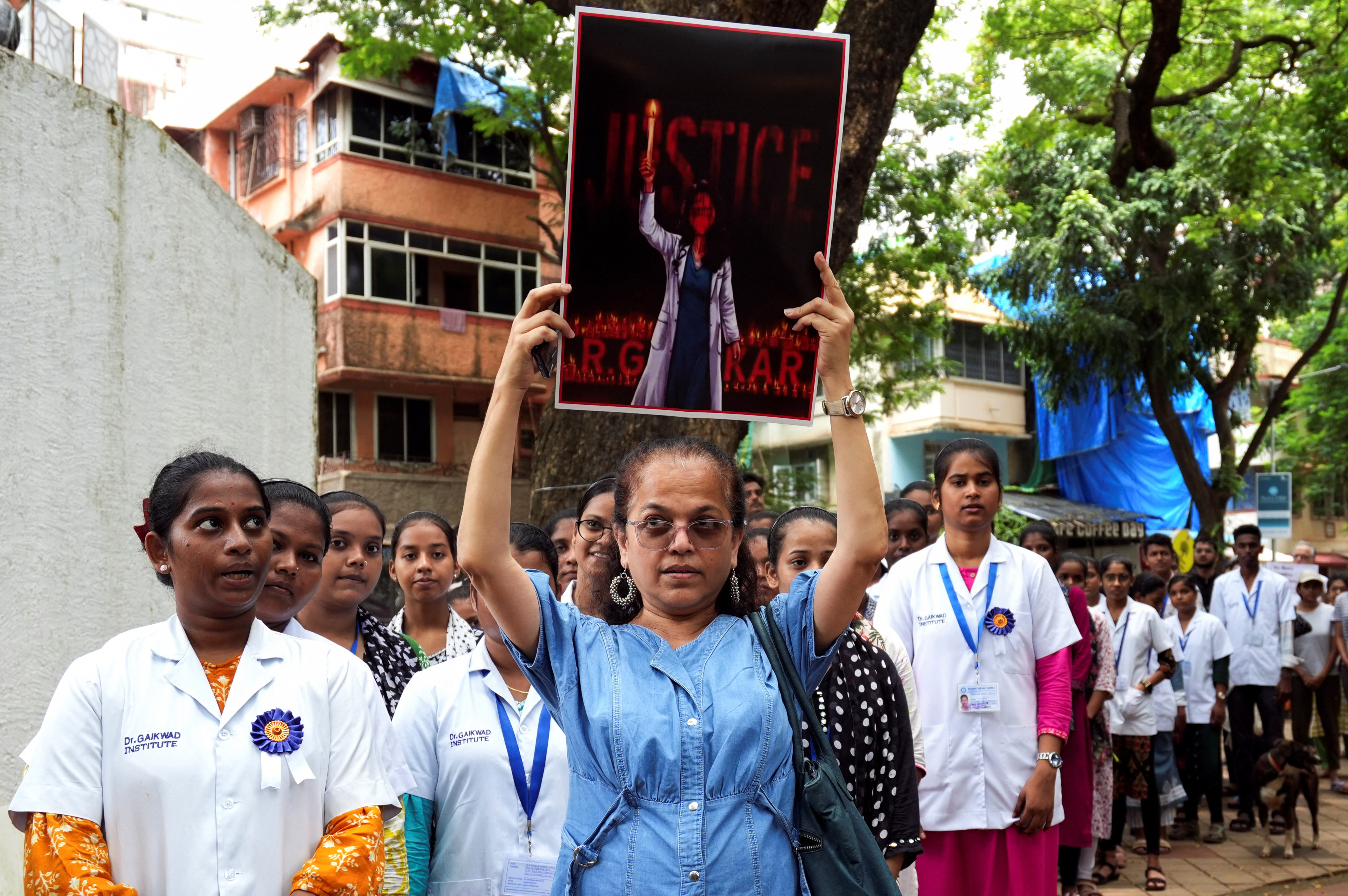 Doctors and residents hold posters and shout slogans during a protest condemning the rape and murder of a trainee medic at a government-run hospital in Kolkata, at a ground in Mumbai