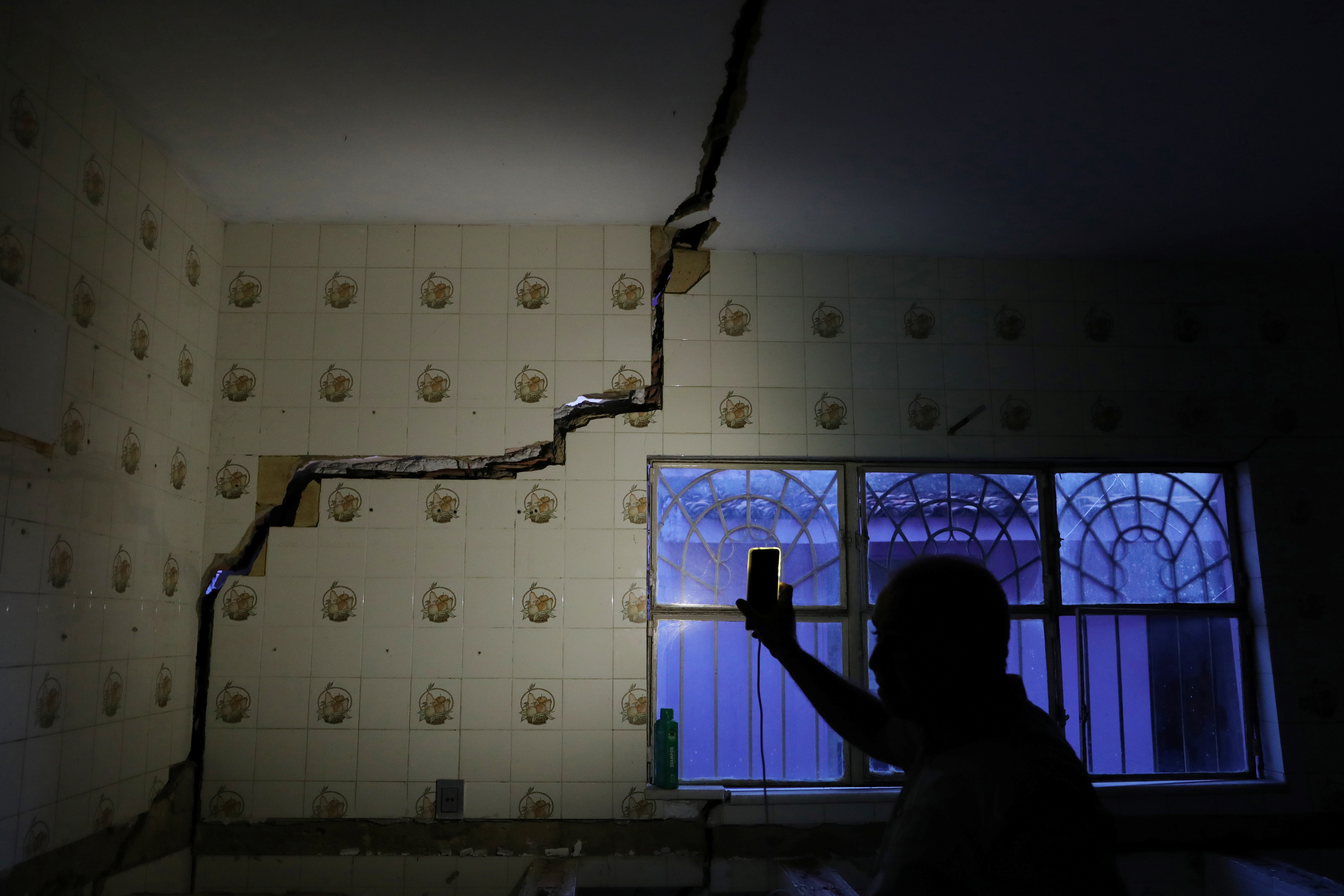 FILE PHOTO: Jose Rinaldo Januario shows a damage in his house linked to rock salt mining by the petrochemical company Braskem in Maceio