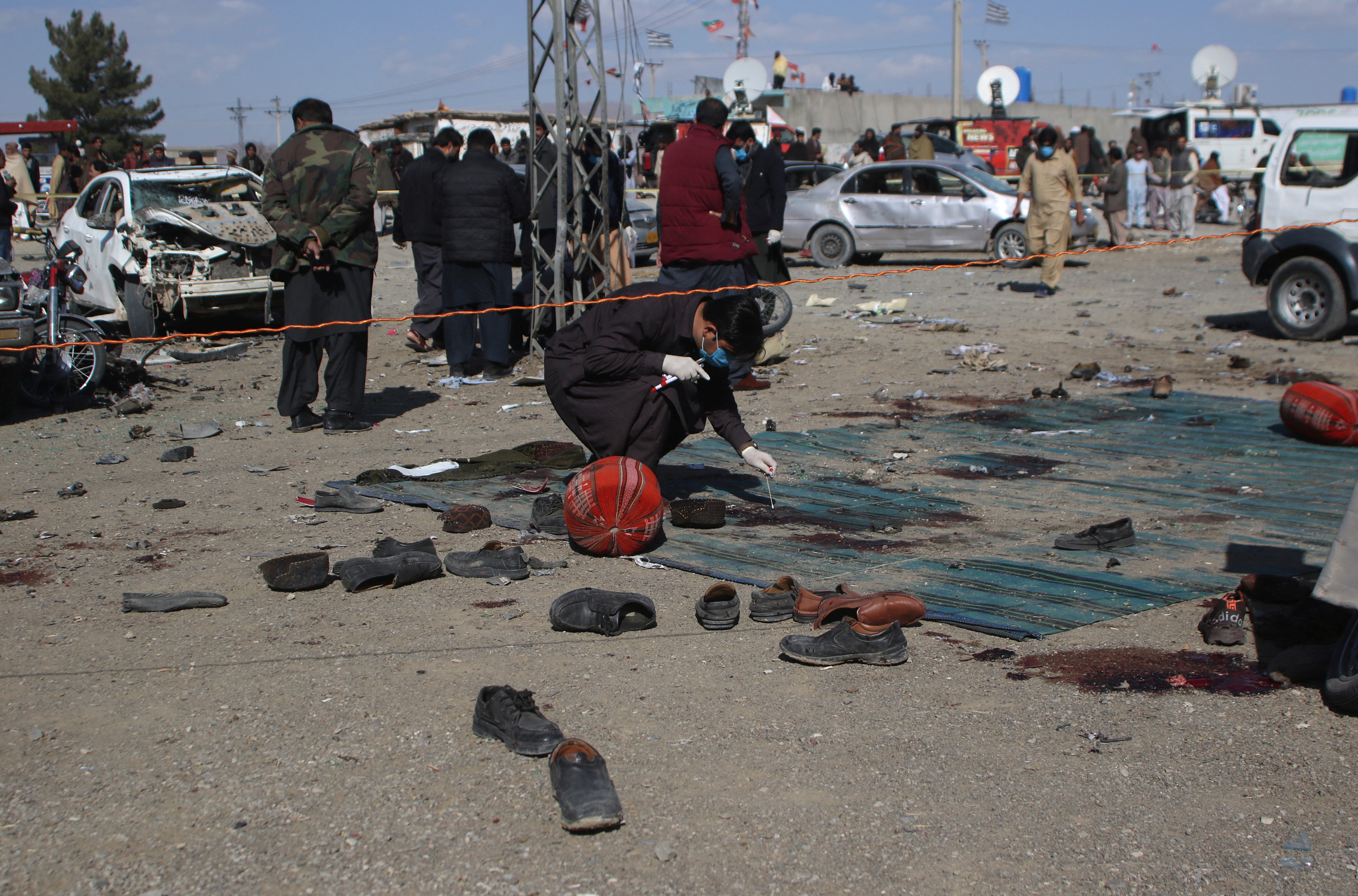 Members of a bomb disposal squad examine the site of a blast in Khanozai
