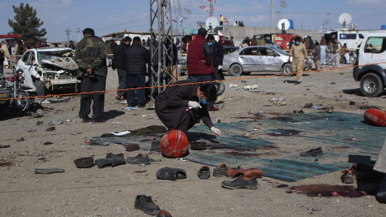 Members of a bomb disposal squad examine the site of a blast in Khanozai