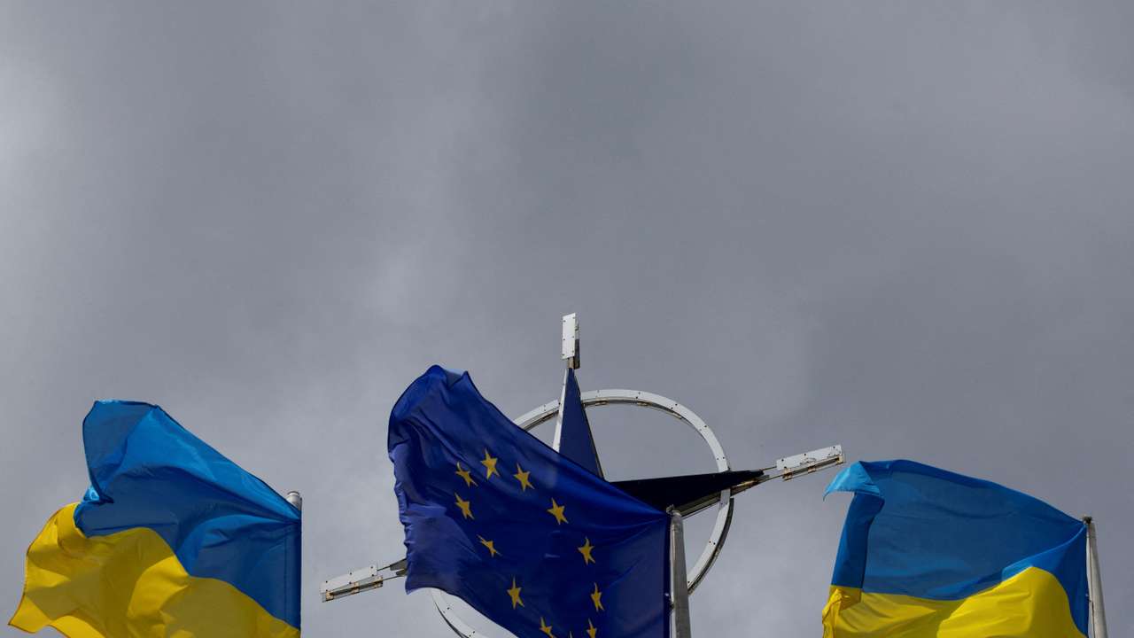 FILE PHOTO: National flags of Ukraine and EU rise in front of the NATO emblem in central Kyiv