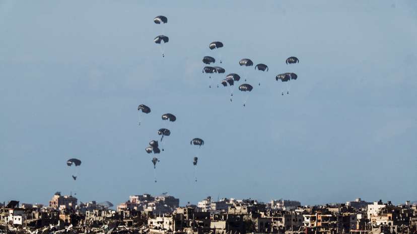 Packages dropped from a military aircraft fall towards northern Gaza, as seen from Israel