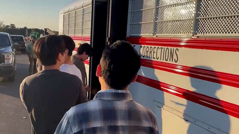 Detainees board a bus during a raid by federal agents in Ellabell