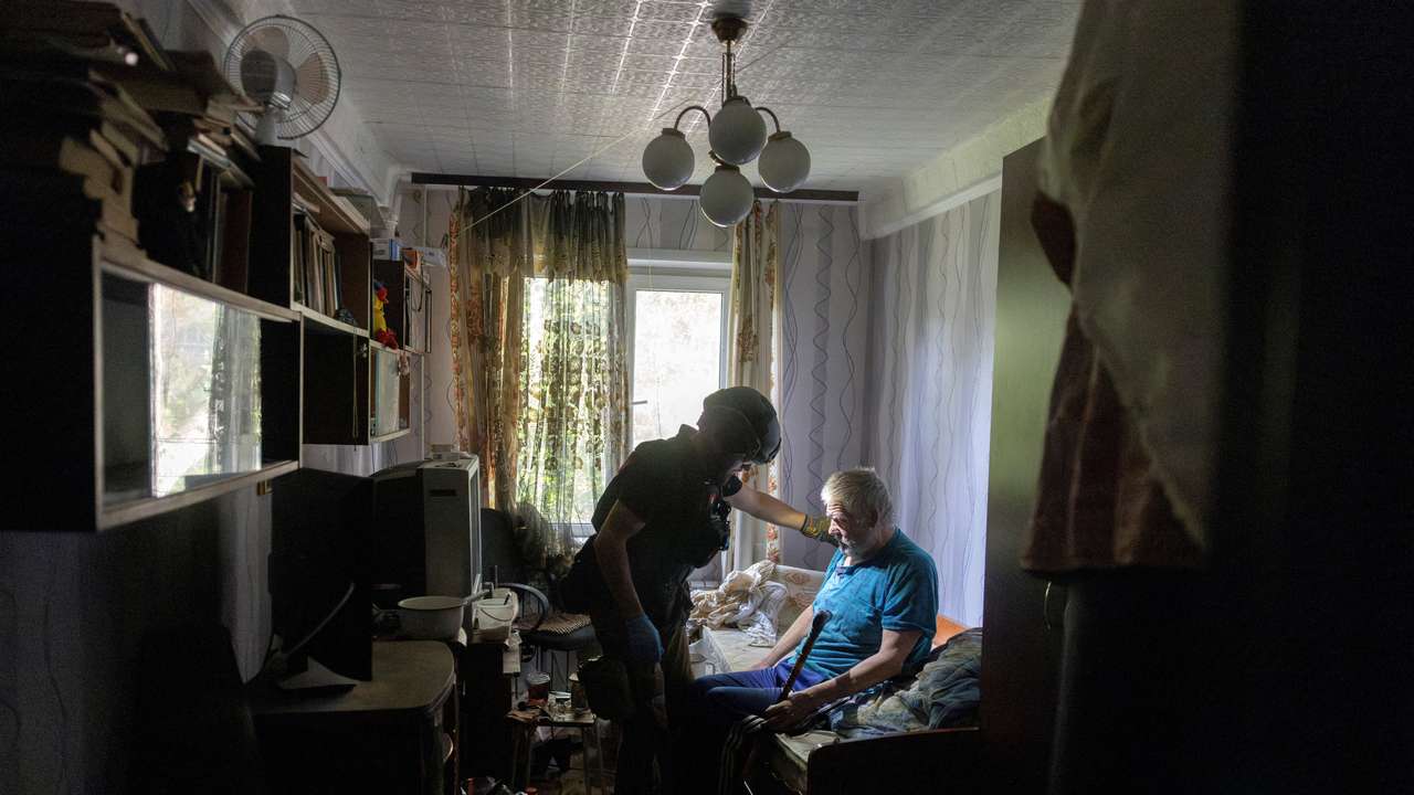 A volunteer of East SOS assists a resident who is evacuating his home because of Russian advances in Selydove near Pokrovsk