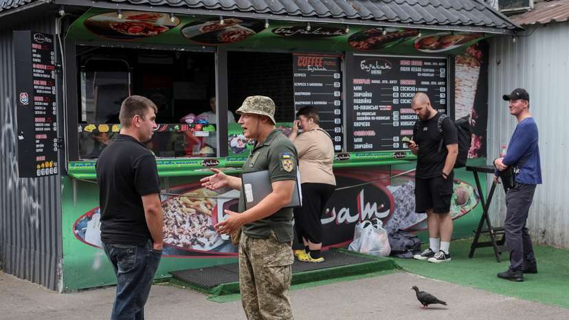 A recruiters officer with the call sign 'Fantomas' checks papers of men and hands out military summonses in Kyiv