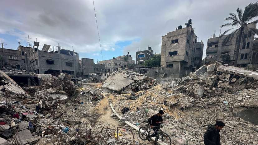 Palestinians inspect houses, destroyed in Israeli strikes during the conflict, at Khan Younis refugee camp