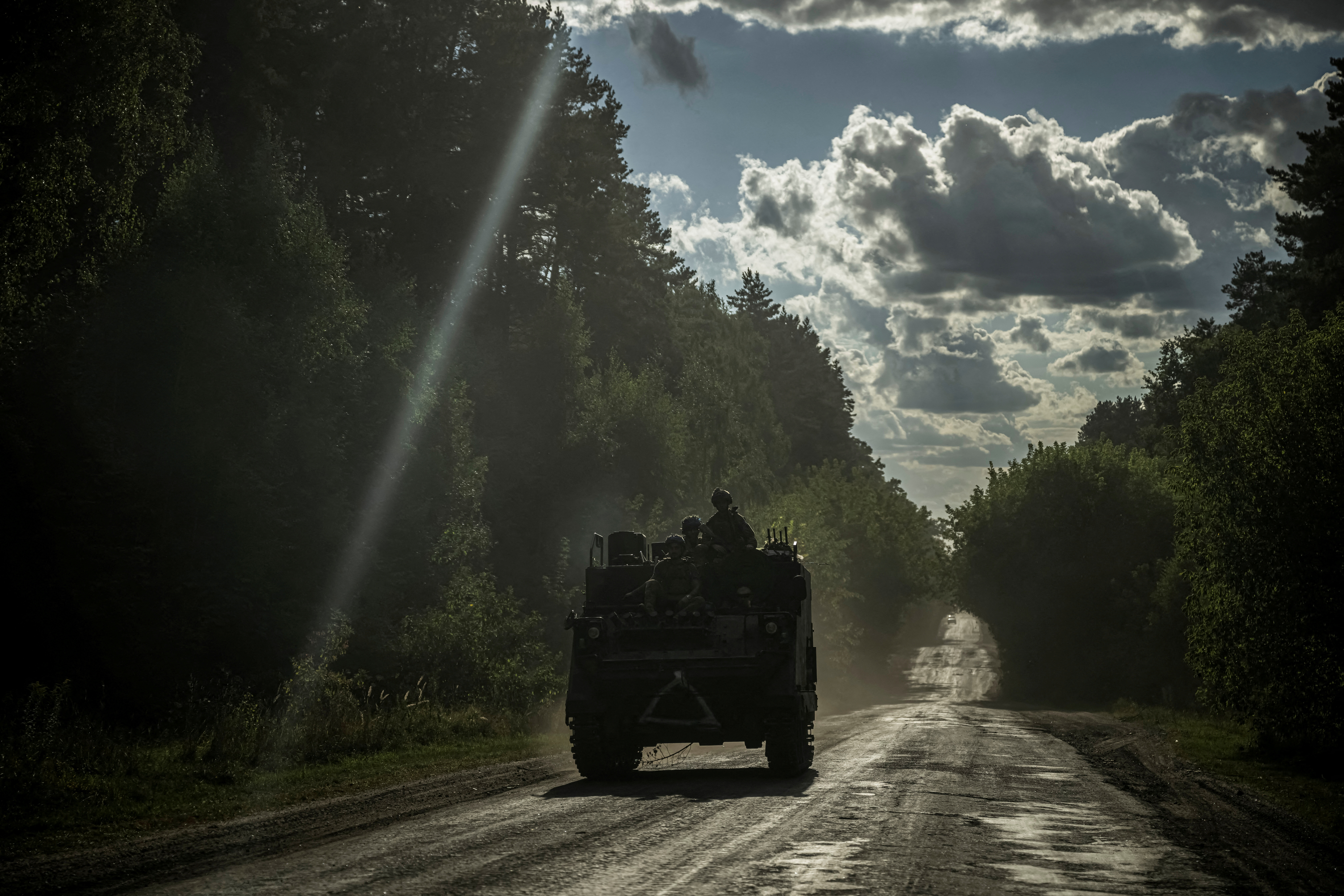 FILE PHOTO: Ukrainian servicemen ride a military vehicle near the Russian border in Sumy region