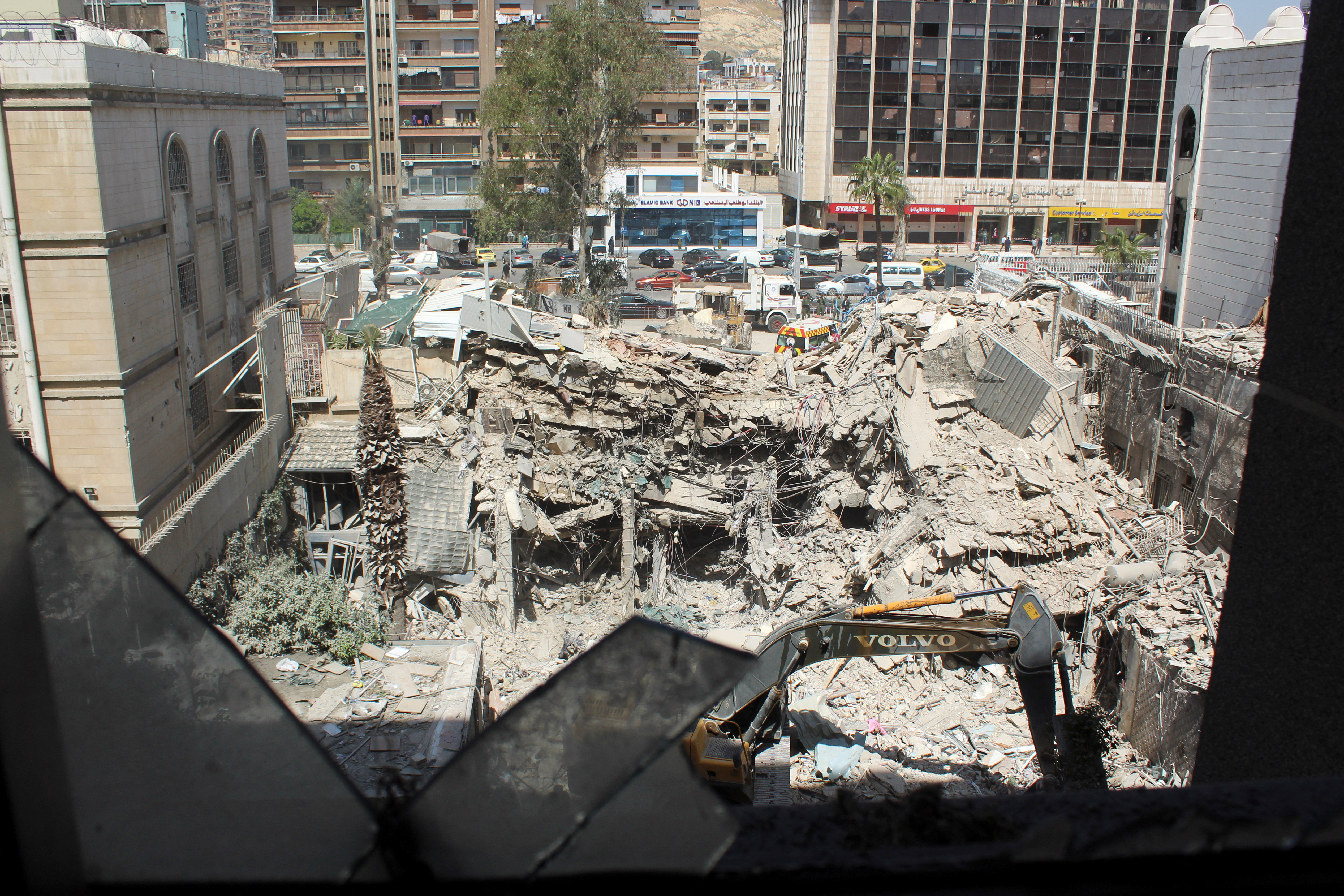 An excavator clears rubble after a suspected Israeli strike on Iran's consulate, in Damascus