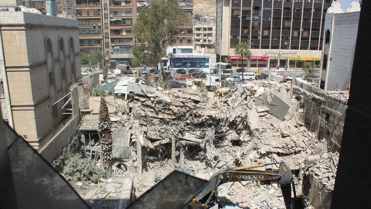 An excavator clears rubble after a suspected Israeli strike on Iran's consulate, in Damascus