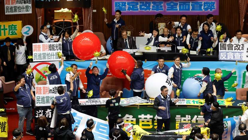 Lawmakers take part in a session as some hold inflatable balloons, at the Parliament in Taipei