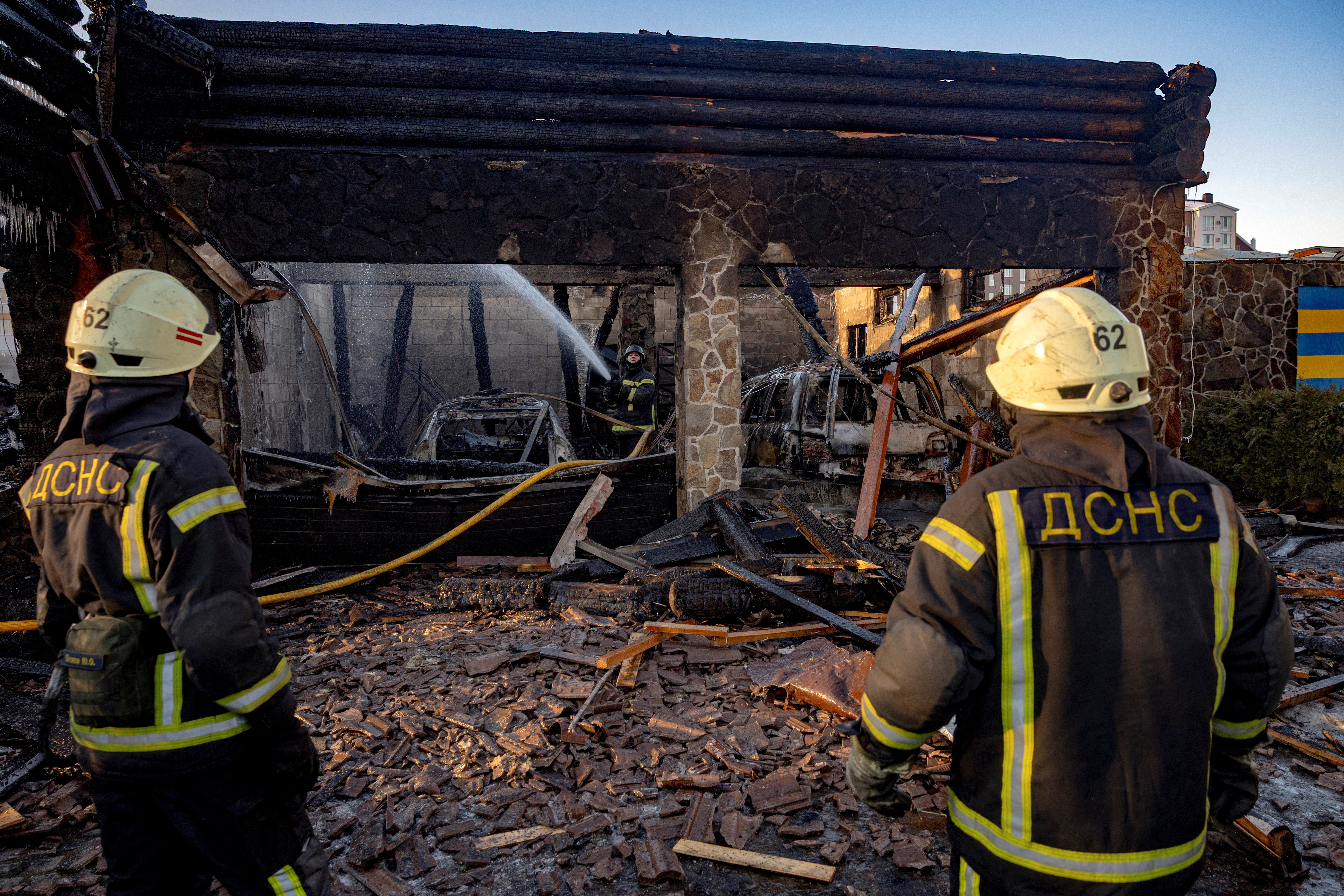 Firefighters work at a site of a Russian drone strike in Kyiv