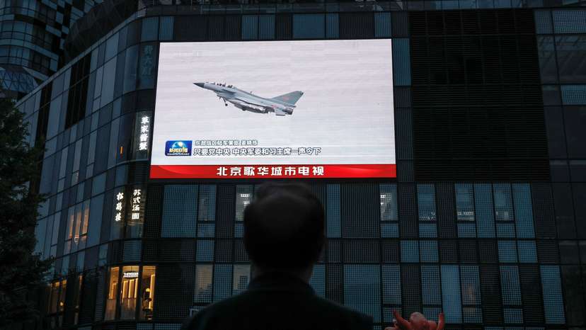 A screen shows news footage of military drills conducted in areas around the island of Taiwan by the Eastern Theatre Command of the PLA in Beijing