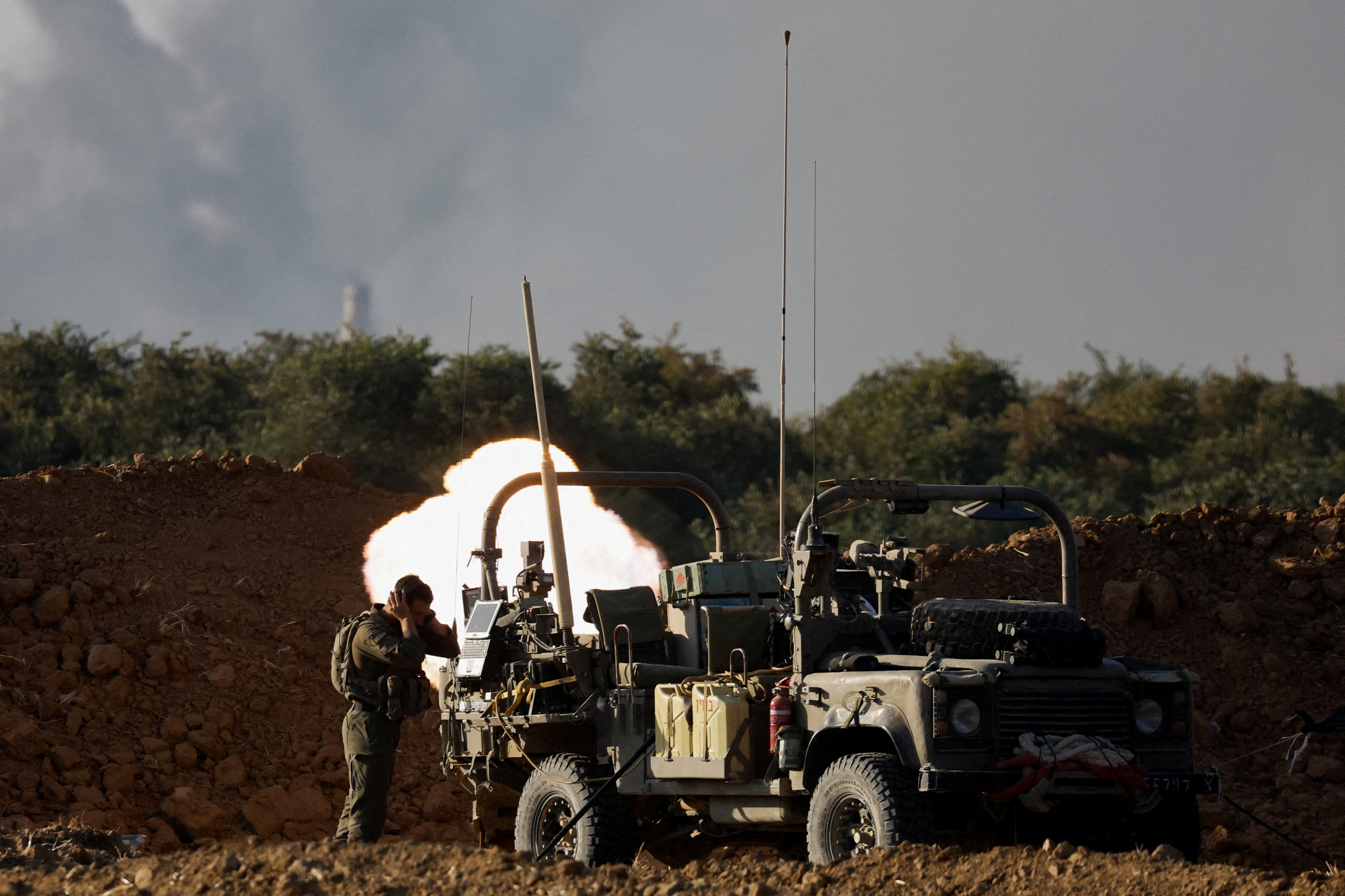 FILE PHOTO: Israeli soldiers fire a mortar, amid the Israel-Hamas conflict, near the Israel-Gaza border