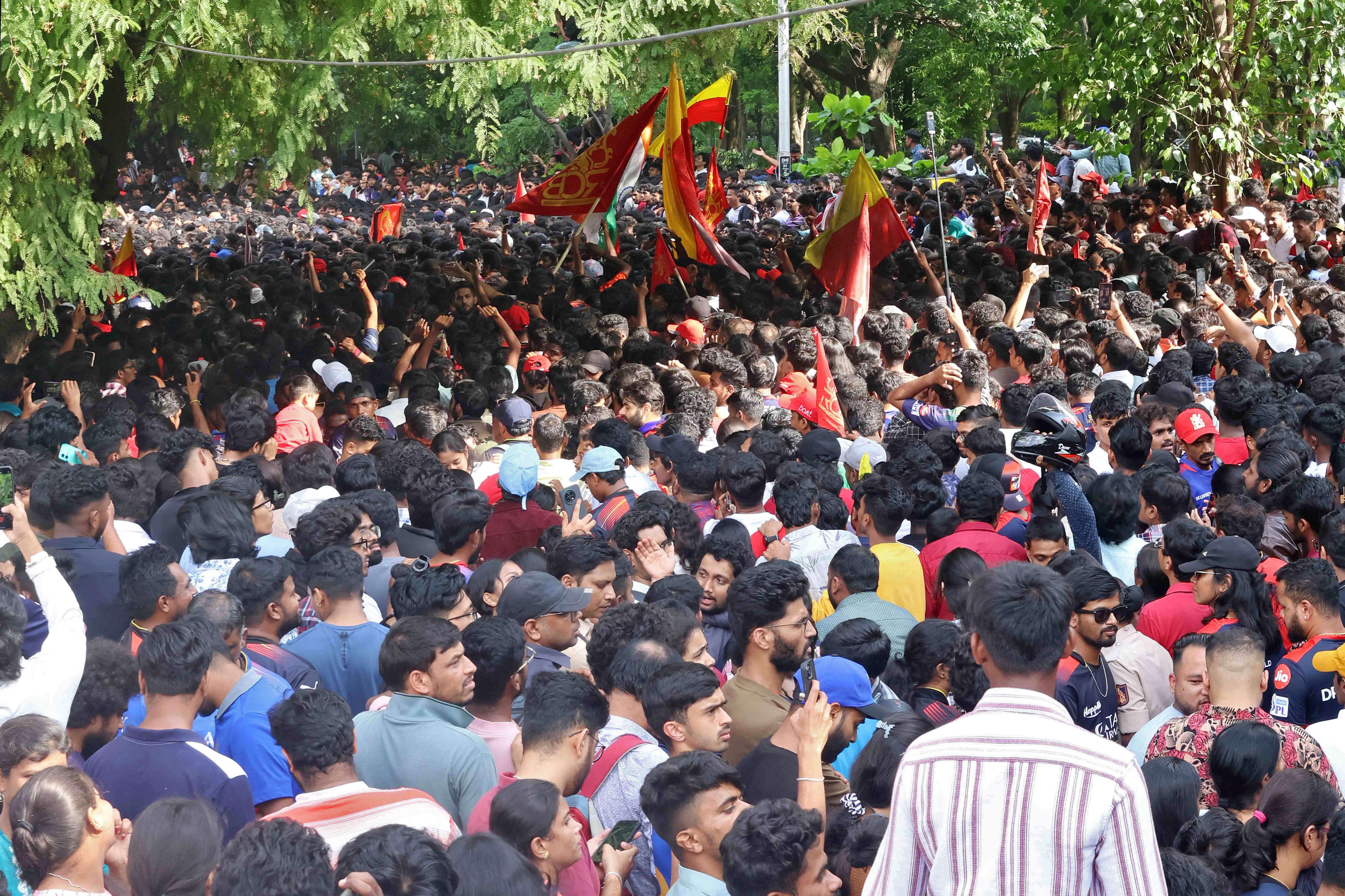 People gather to celebrate Royal Challengers Bengaluru's first Indian Premier League (IPL) title win, outside a cricket stadium in Bengaluru