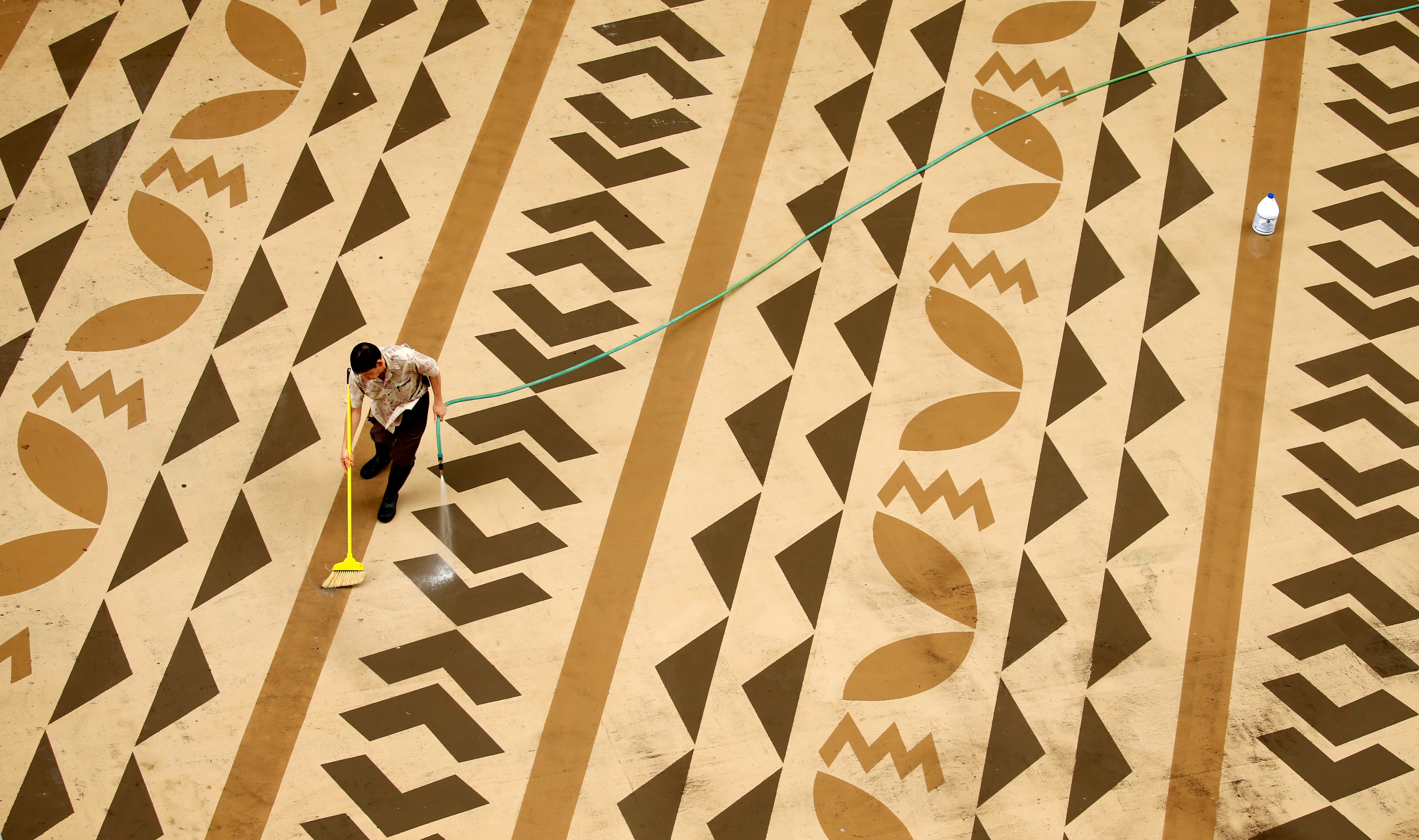 A worker cleans a deck on Waikiki Beach in Hawaii