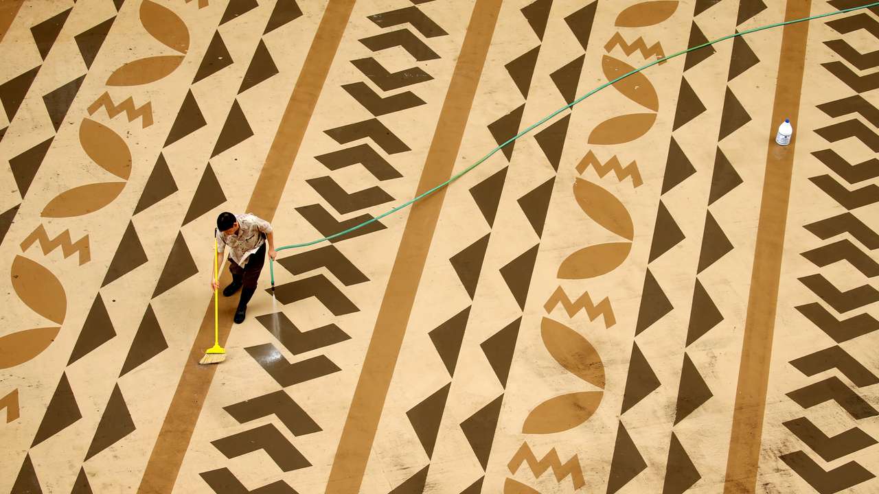 A worker cleans a deck on Waikiki Beach in Hawaii