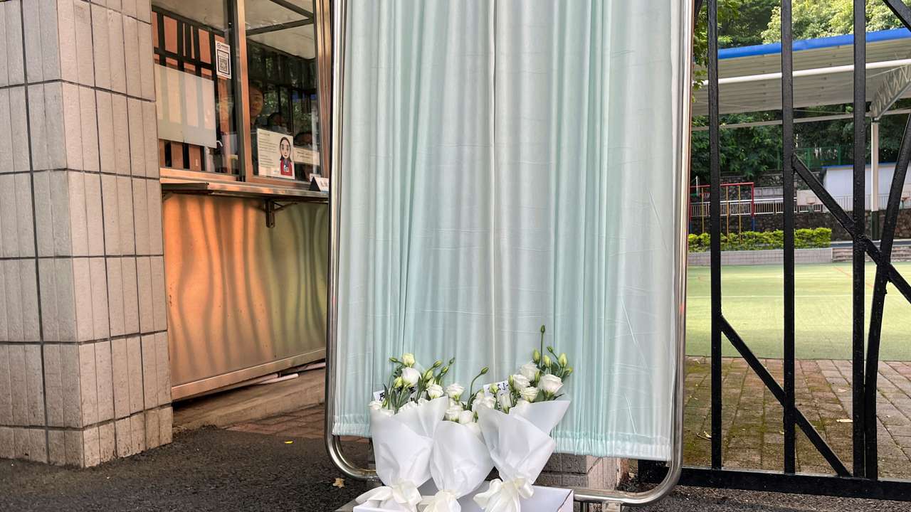 Flower bouquets lay outside Shenzhen Japanese School in Shenzhen