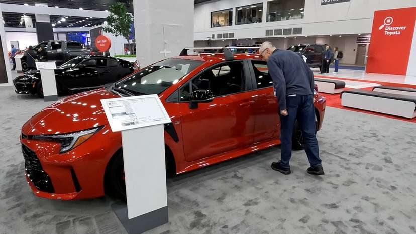 FILE PHOTO: A man gazes into the window of the 2025 Toyota Corolla Hatchback on display during media preview day at the Detroit Auto Show, in Detroit