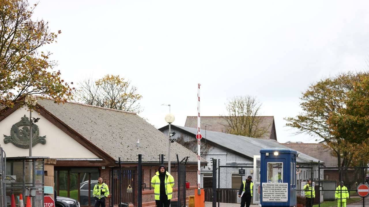 Security guards stand at the entrance to a migrant processing centre in Manston