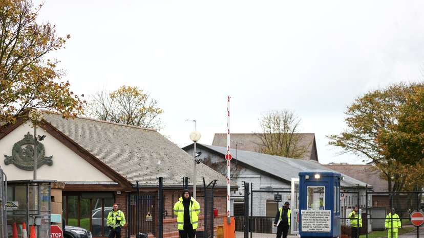 Security guards stand at the entrance to a migrant processing centre in Manston