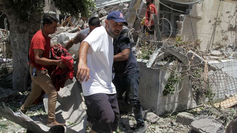 Palestinians search for casualties outside UNRWA headquarters, following an Israeli strike, in Gaza City