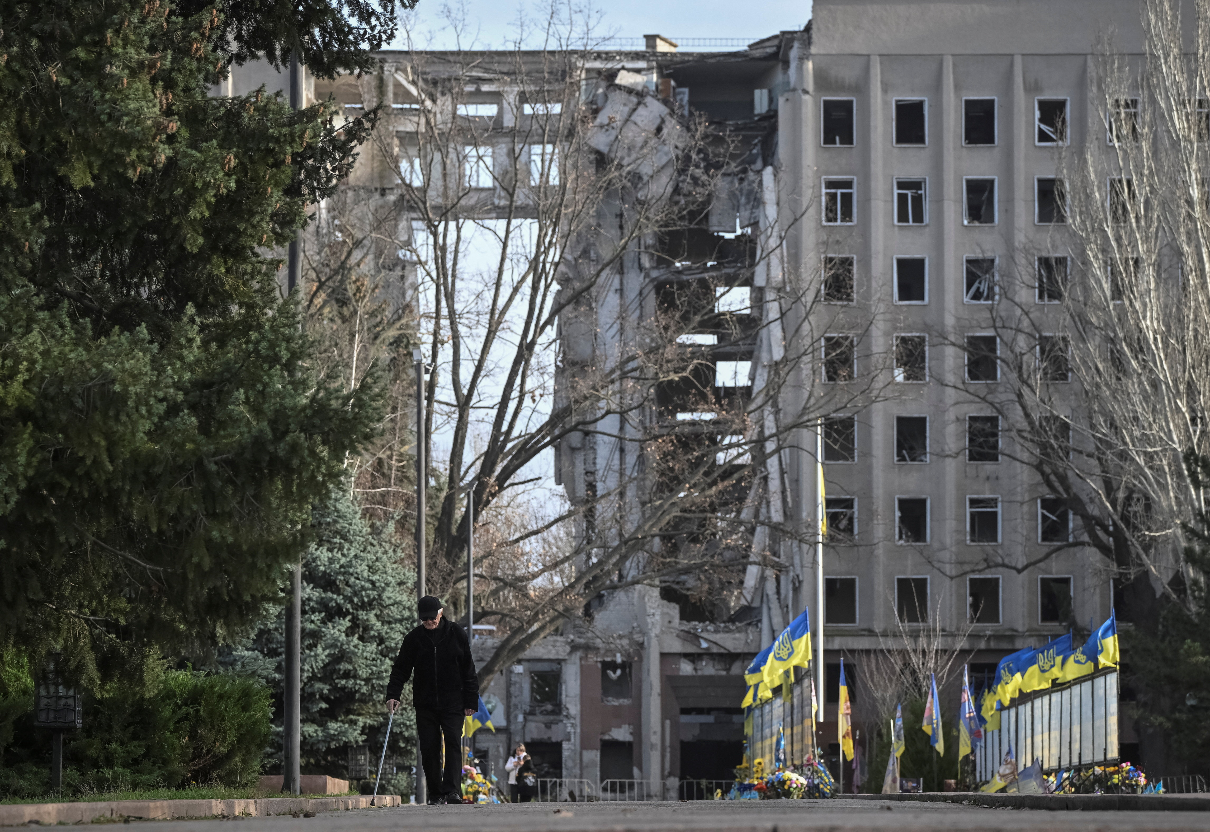A man walks next to a damaged building in Mykolaiv