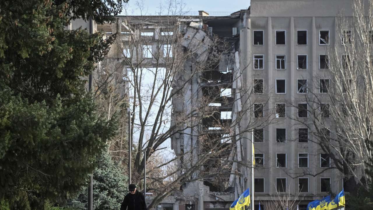 A man walks next to a damaged building in Mykolaiv