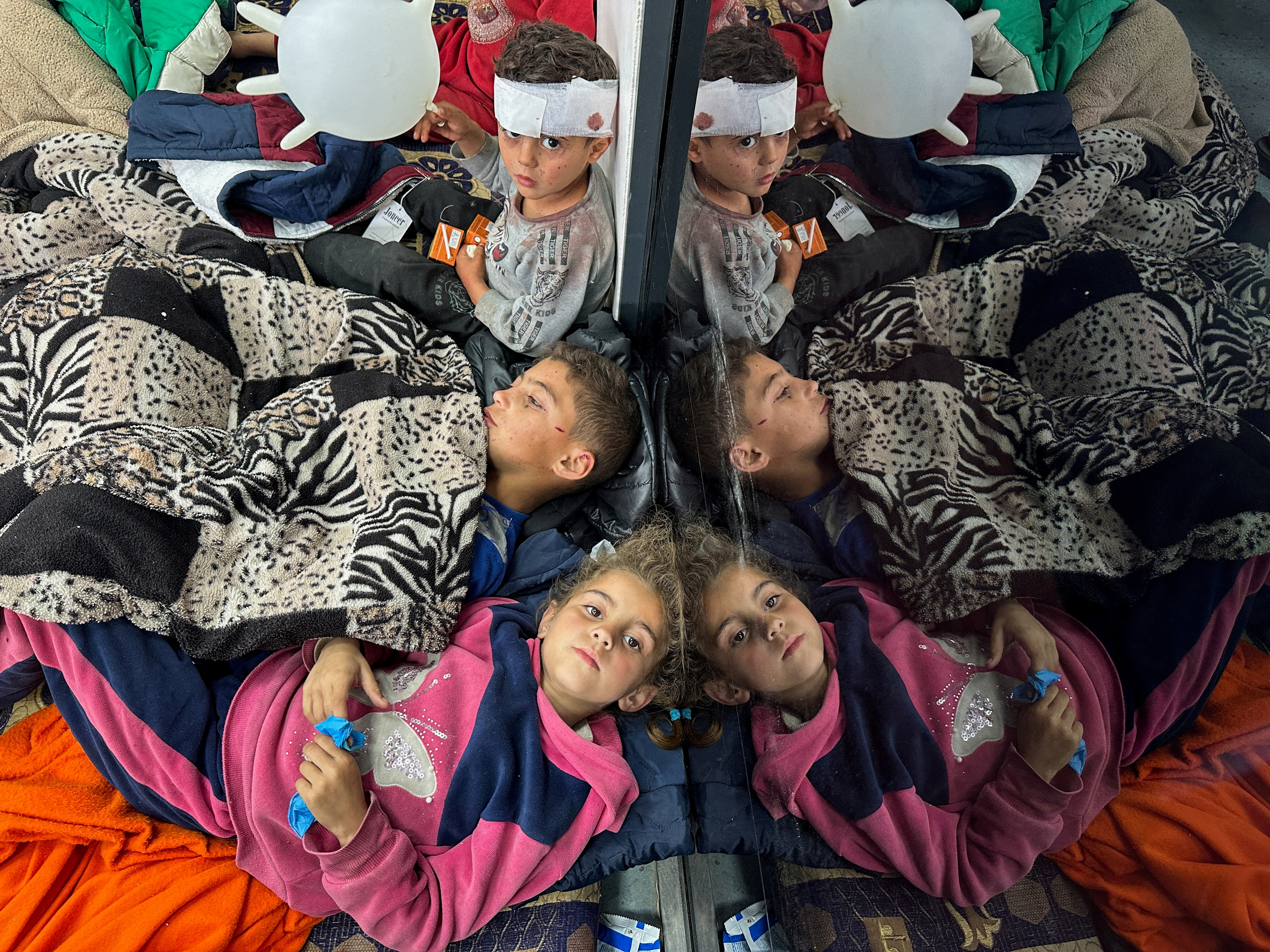 FILE PHOTO: Palestinian children wounded in an Israeli strike rest as they receive treatment at a hospital, in Rafah