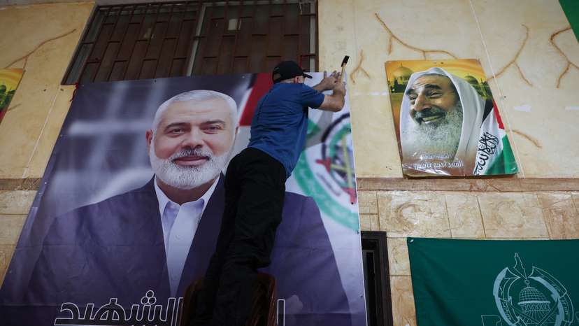 A man hangs a picture of assassinated Hamas leader Haniyeh at Palestinian refugee camp in Beirut