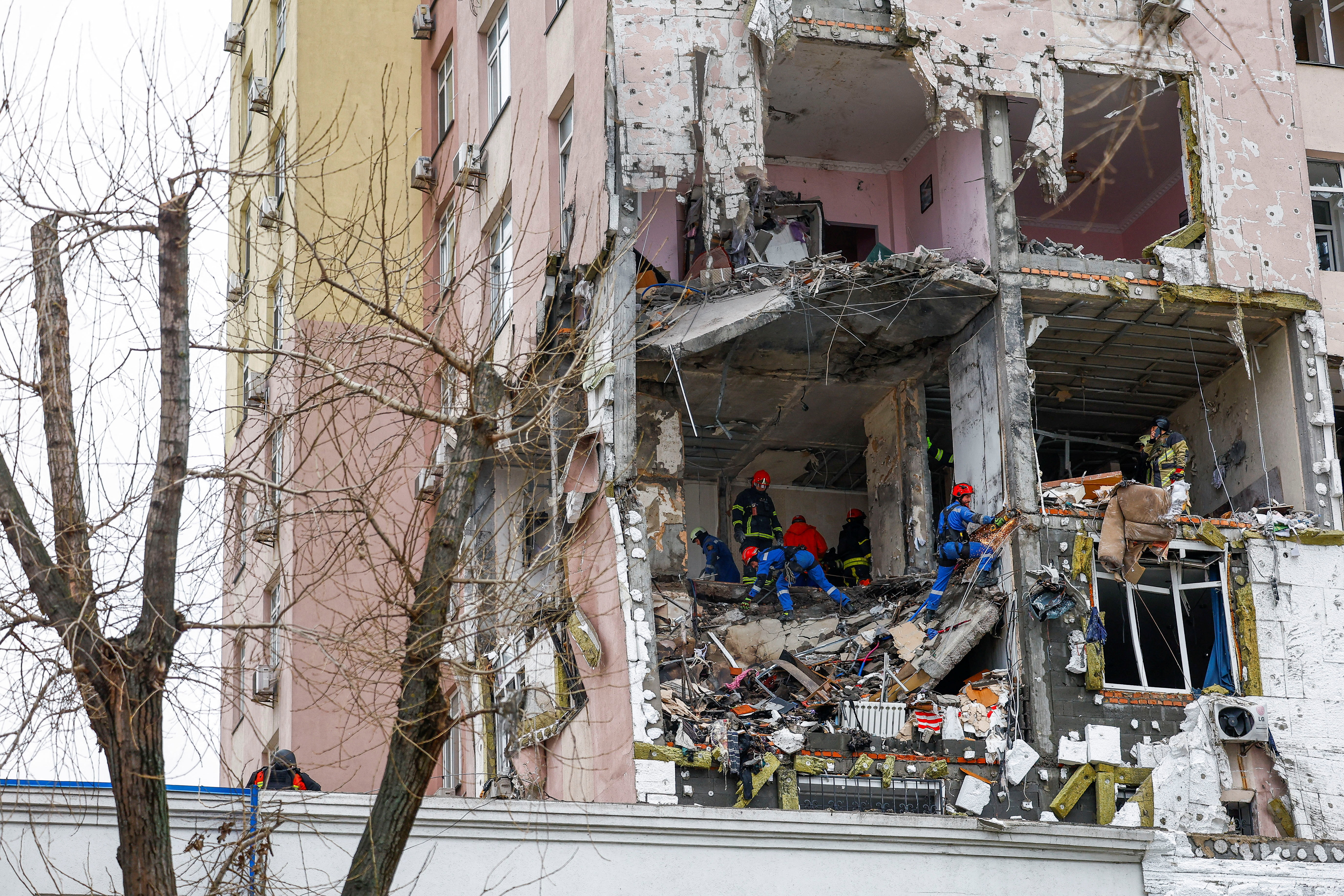 Firefighters work at the site of an apartment building hit during Russian missile and drone strikes, amid Russia’s attack on Ukraine in Kyiv