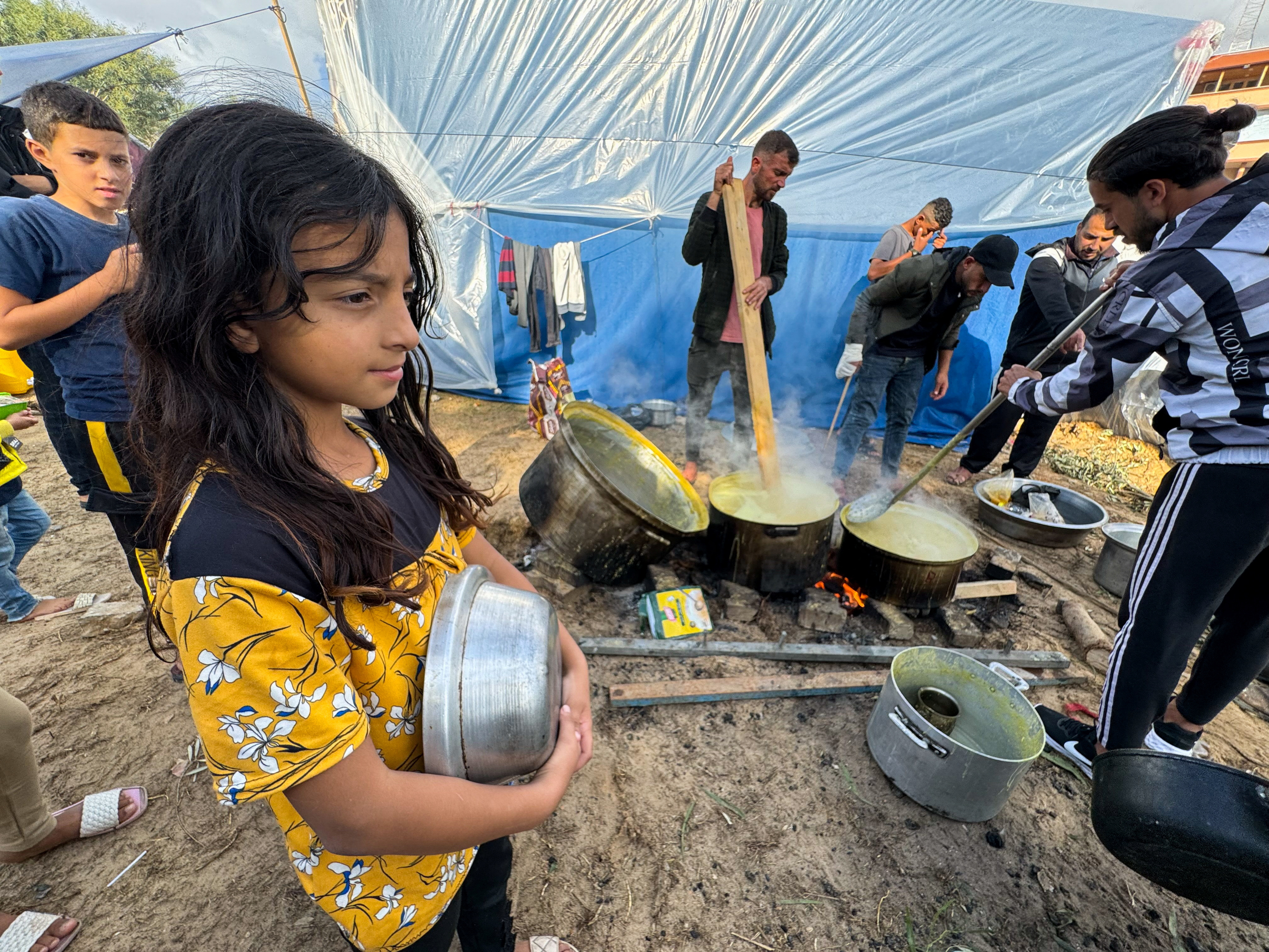 Displaced Palestinians, who fled their houses due to Israeli strikes, cook at Nasser Hospital in Khan Younis