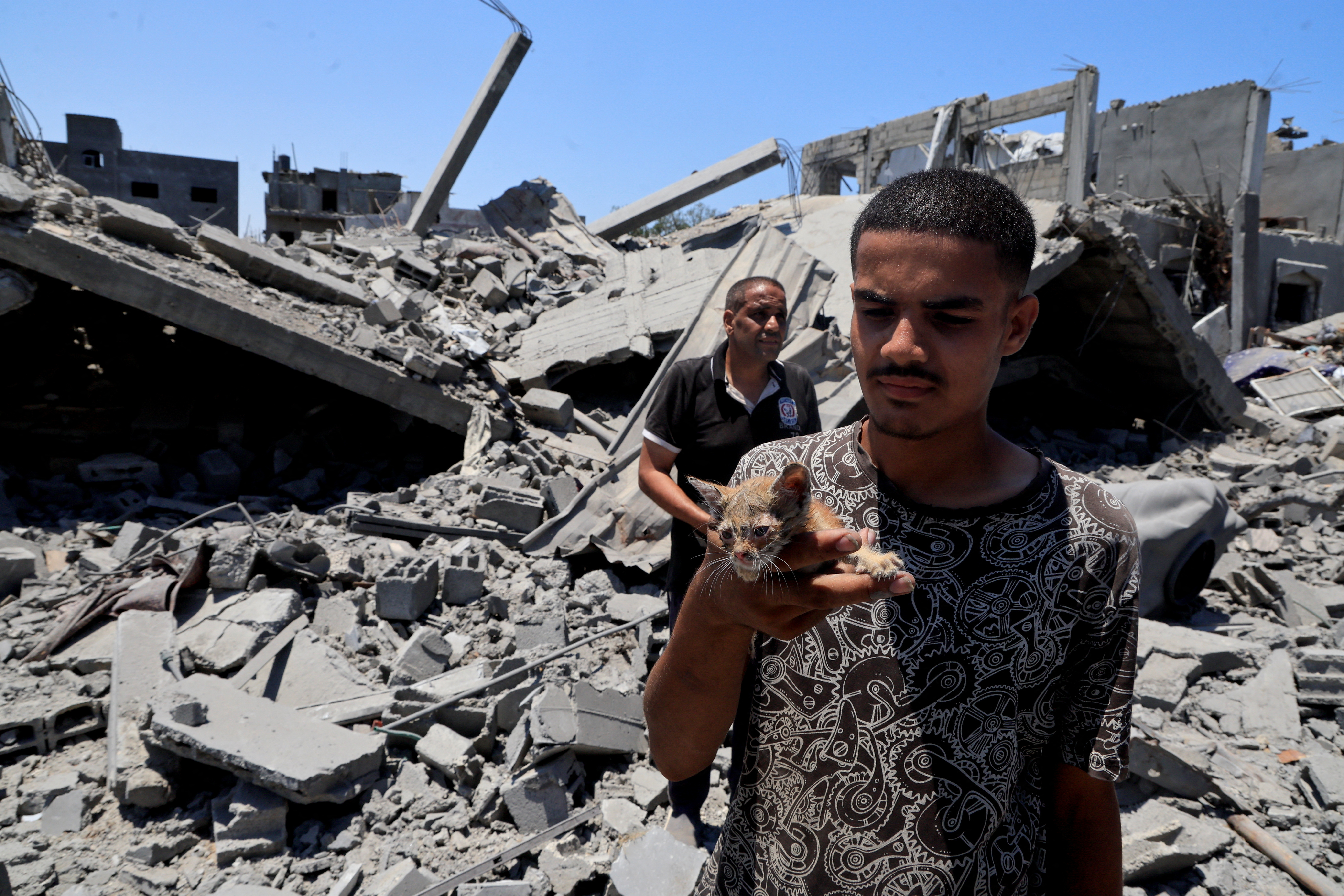 Palestinians inspect houses destroyed during an Israeli military operation, in Deir al-Balah
