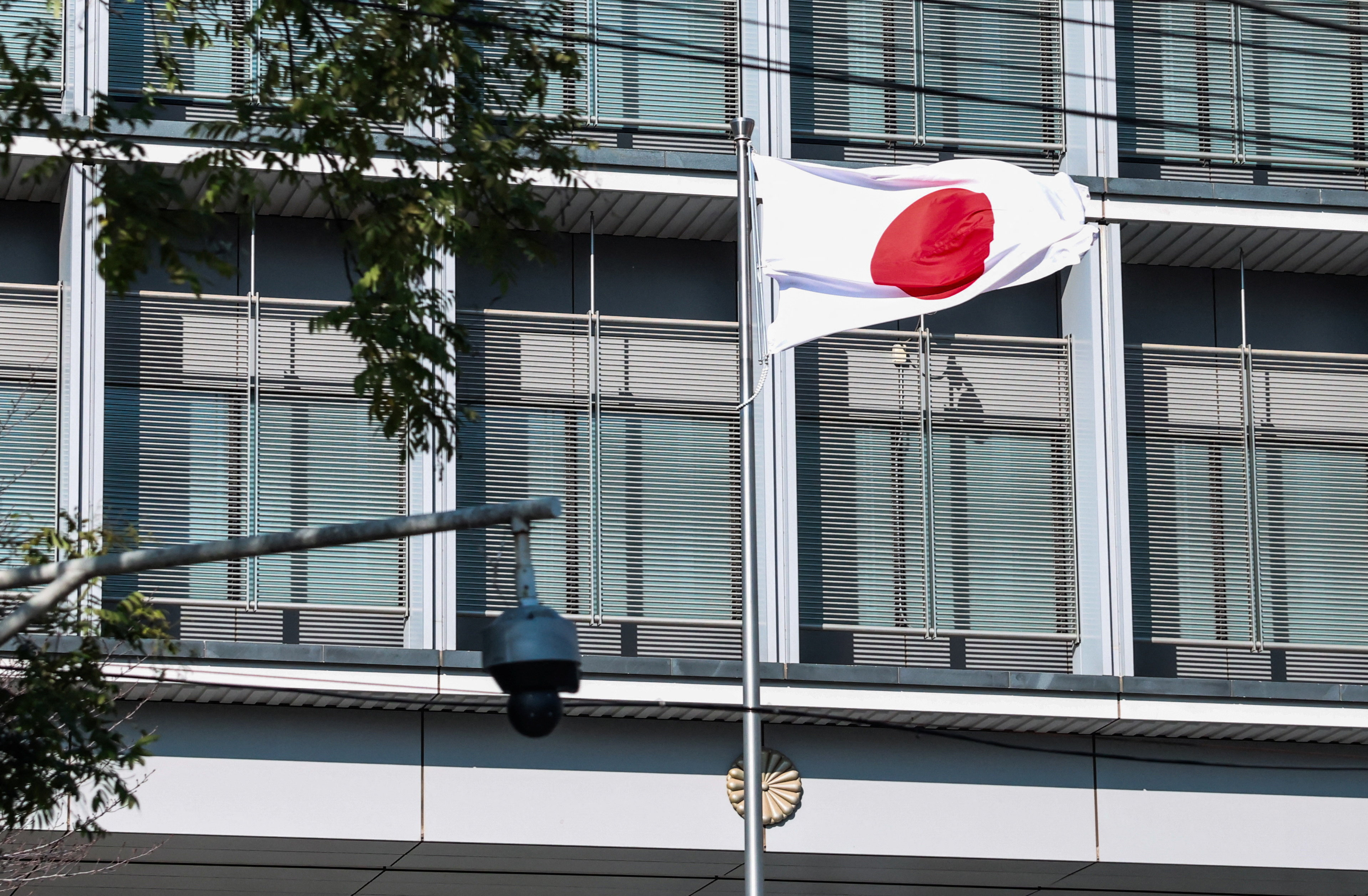 Japan’s national flag flutters next to a surveillance camera at the Embassy of Japan in Beijing