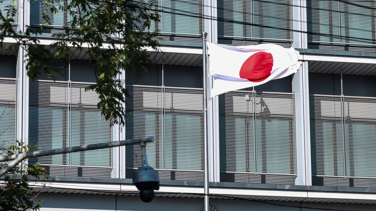 Japan’s national flag flutters next to a surveillance camera at the Embassy of Japan in Beijing