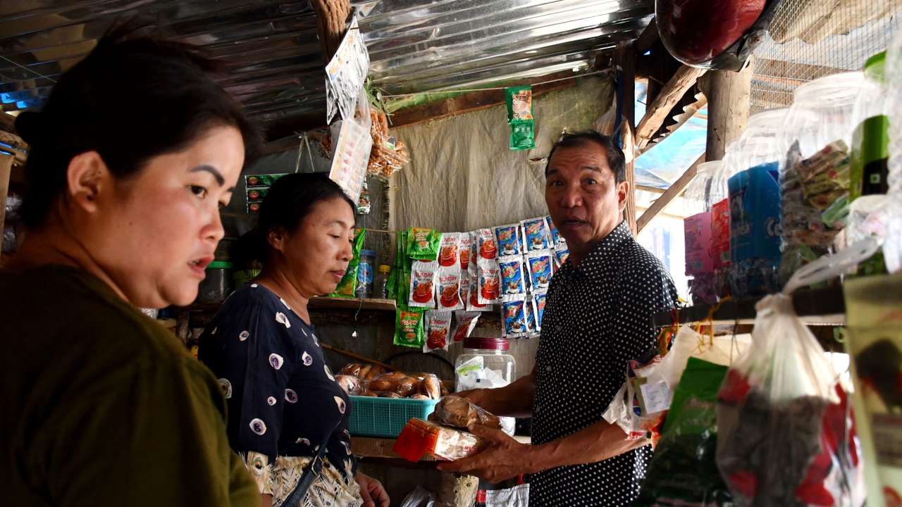 People who fled Myanmar, buy groceries from a makeshift shop in a relief camp at the border village of Zokhawthar