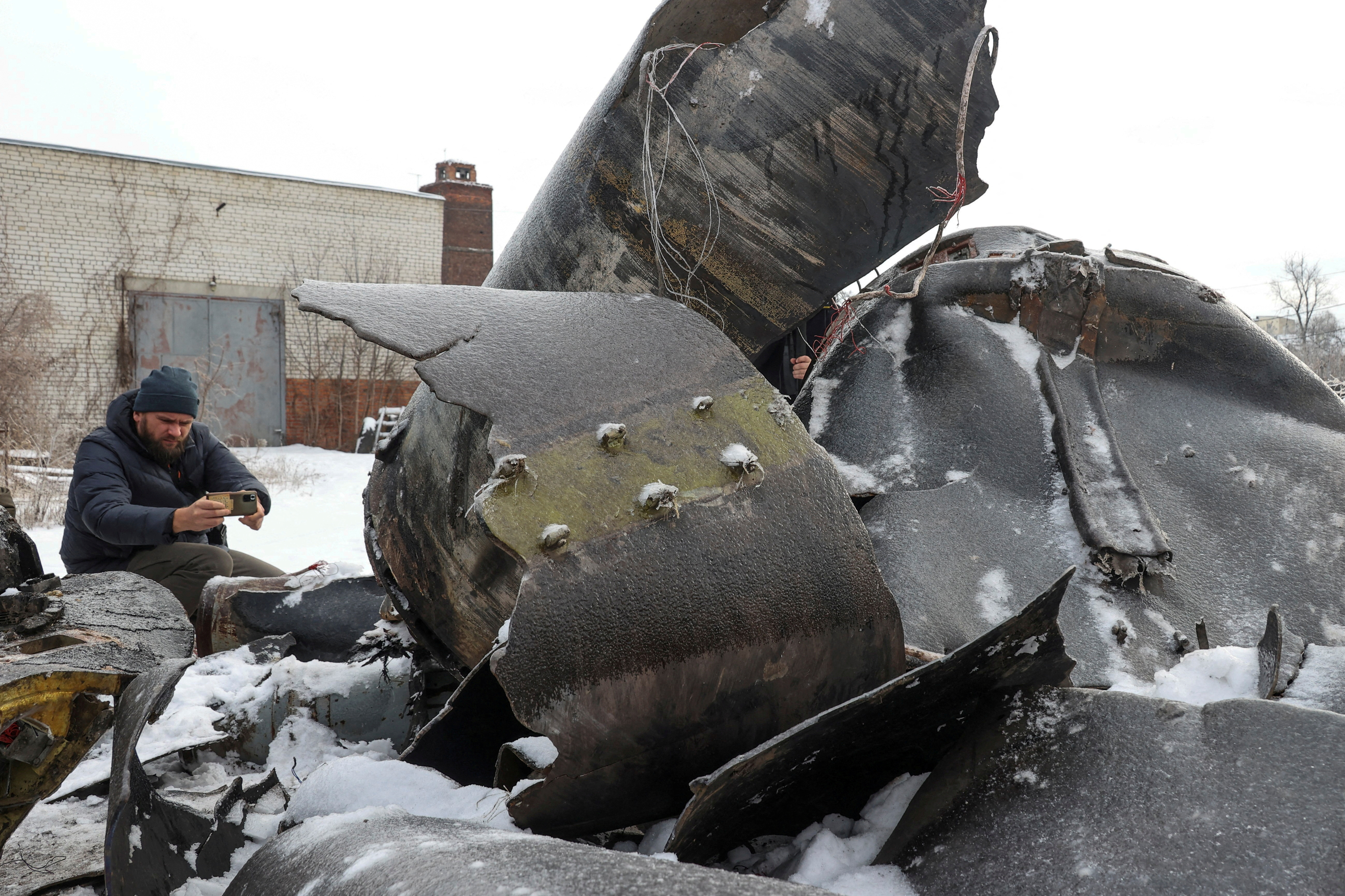 FILE PHOTO: A man photographs parts of an unidentified missile, which Ukrainian authorities believe to be made in North Korea, in Kharkiv