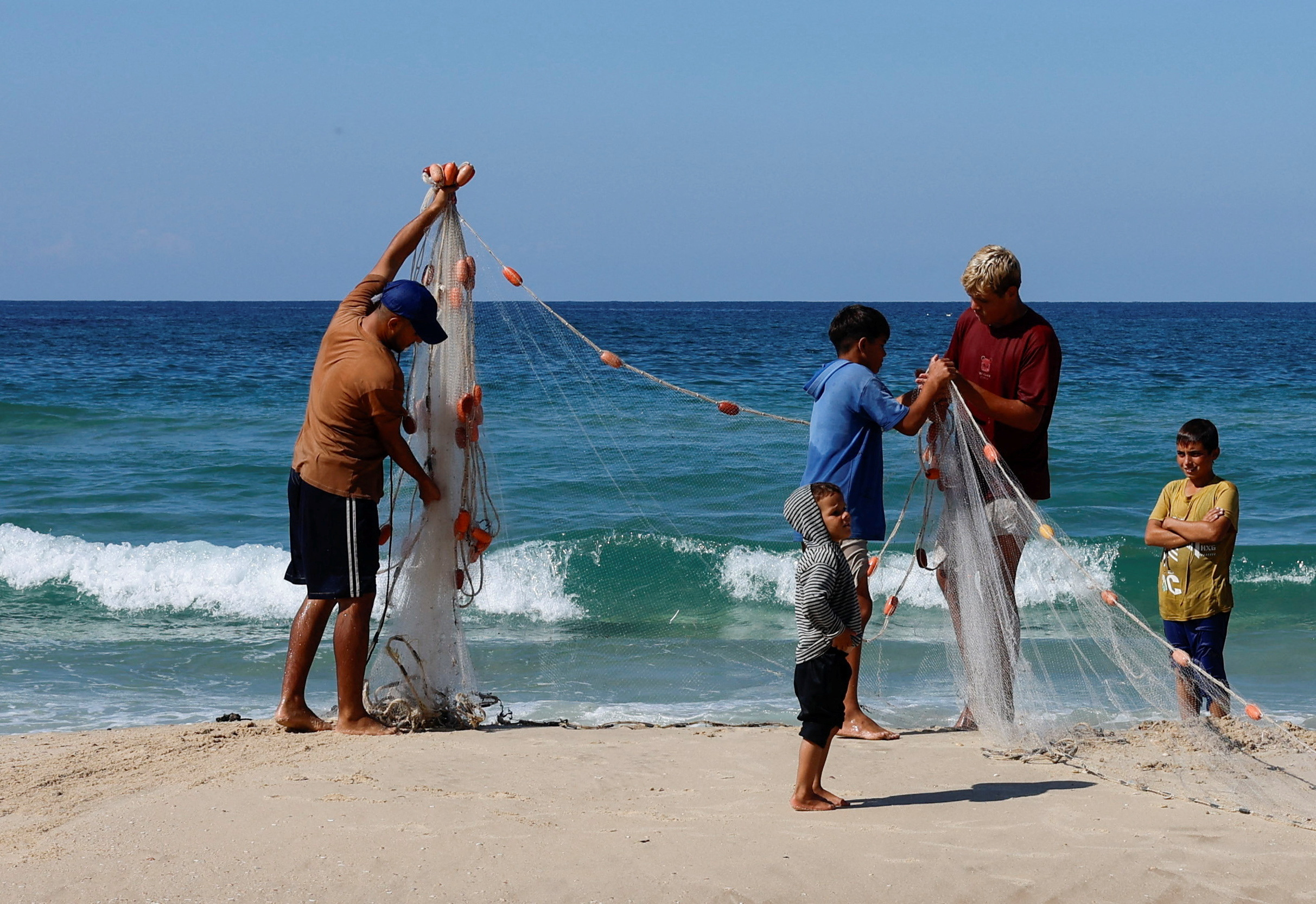 Palestinian fishermen work in Khan Younis