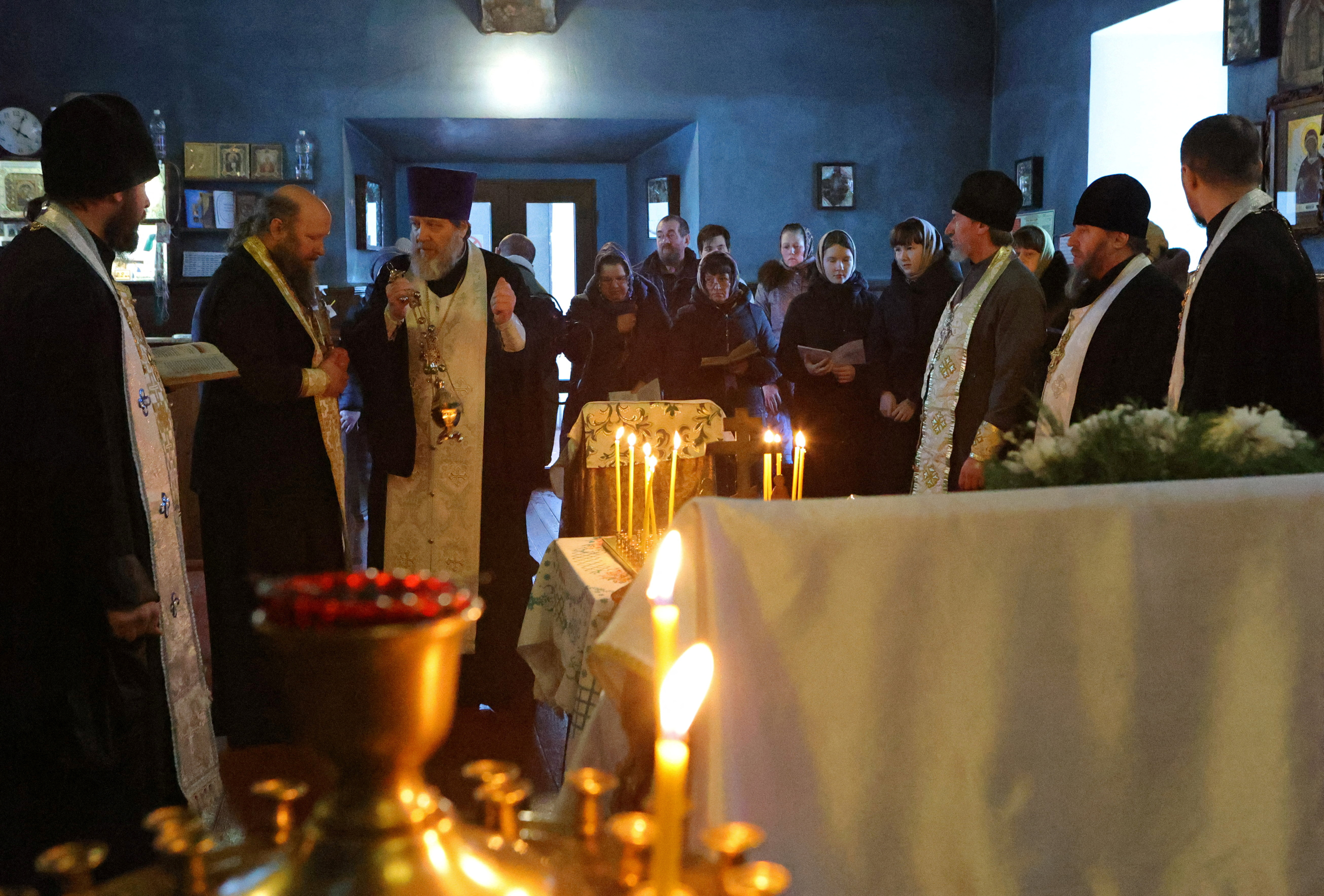 An Orthodox priest conducts a service for those killed in the crash of the Russian Ilyushin Il-76 military transport plane, in Belgorod Region
