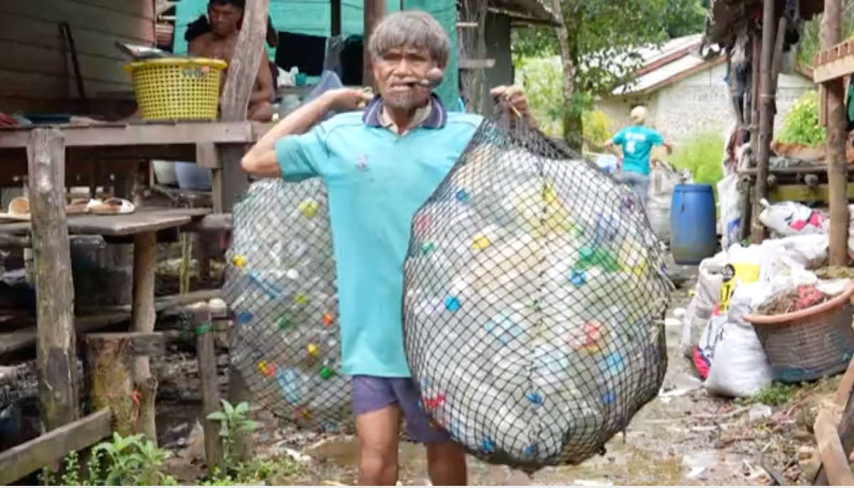 A resident of Moken community collects plastic waste