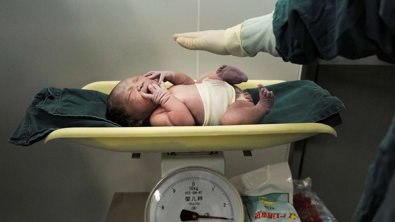 FILE PHOTO: A newborn baby is weighed after it was born at a hospital in Hefei