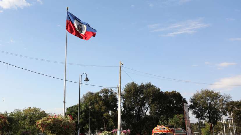 FILE PHOTO: A vehicle drives past Haiti's national flag, in Port-au-Prince