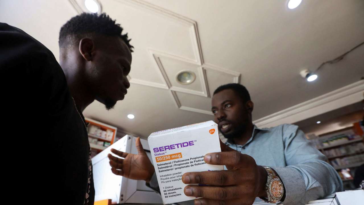Sodiq Ajibade, 29, who suffers from bouts of asthma attacks, speaks to a pharmacist about the Seretide inhaler at a pharmacy in Lagos