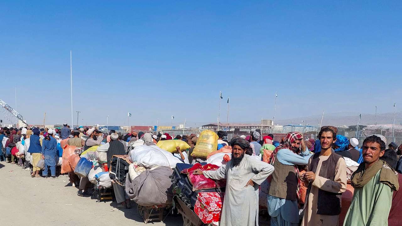 Afghan citizens wait with their belongings to cross into Afghanistan, in Chaman
