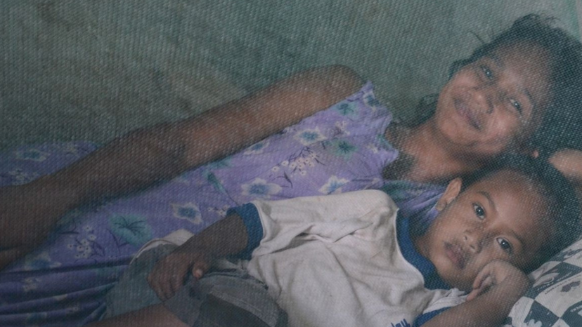 Two children sleep under an insecticide-treated bed net in Fuiloro Village, Lospalos, Timor-Leste.