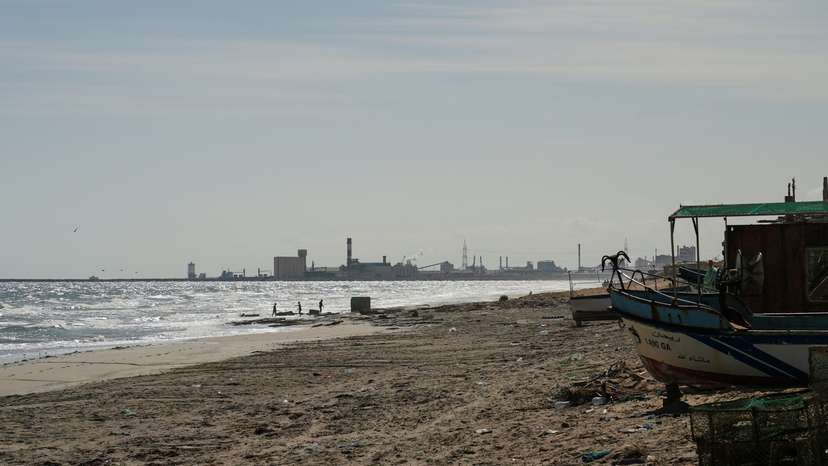 Children play on the beach with the Tunisian Chemical Group’s (CGT) phosphate complex visible in the background, in Gabes