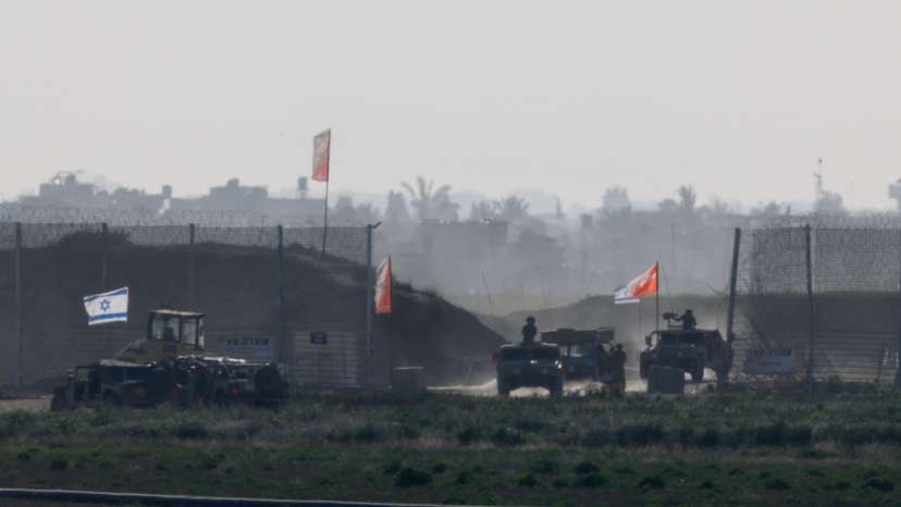 Israeli military vehicles move out from the Gaza Strip, as seen from Israel