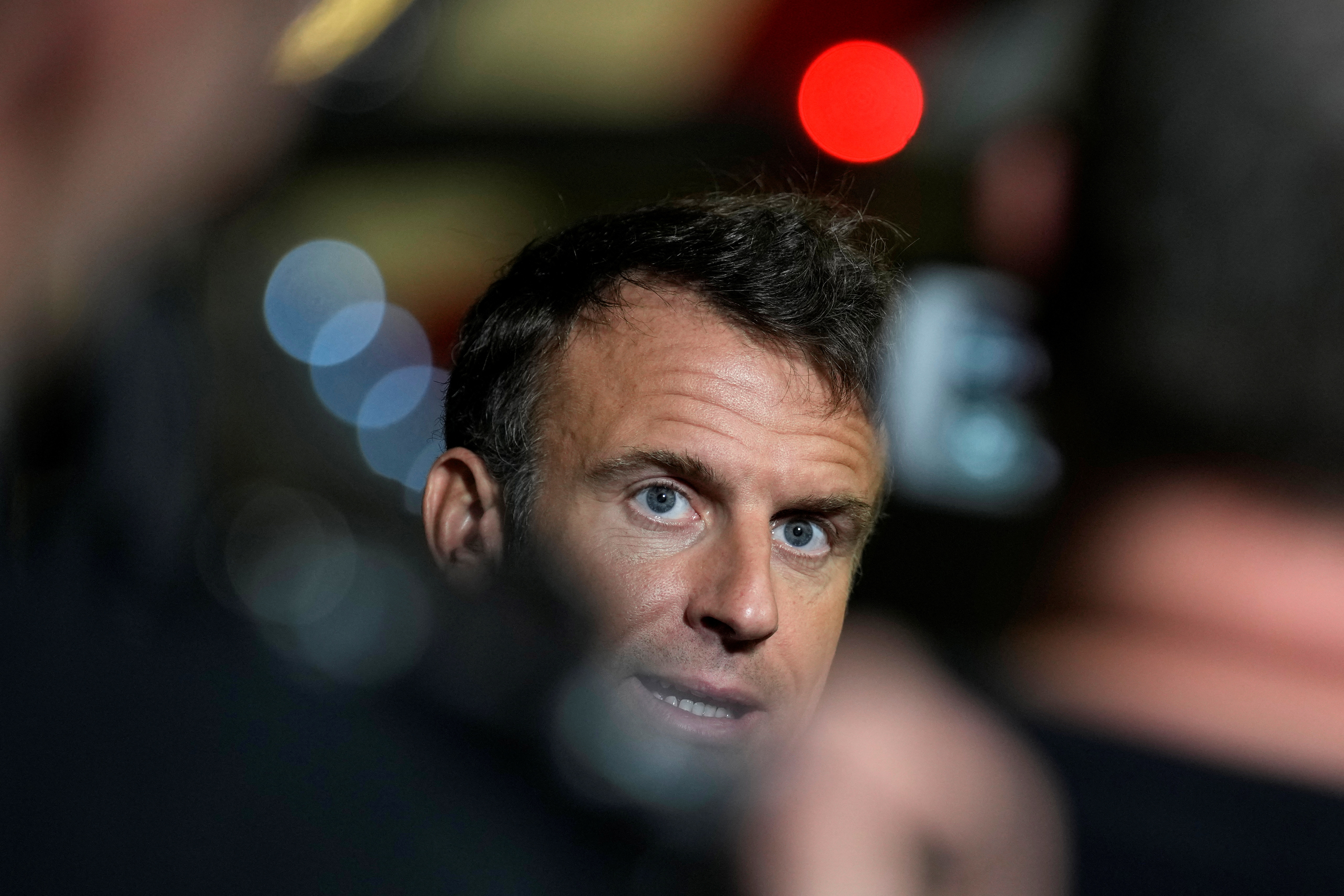 French President Emmanuel Macron talks to journalists on the tarmac of Cairo airport