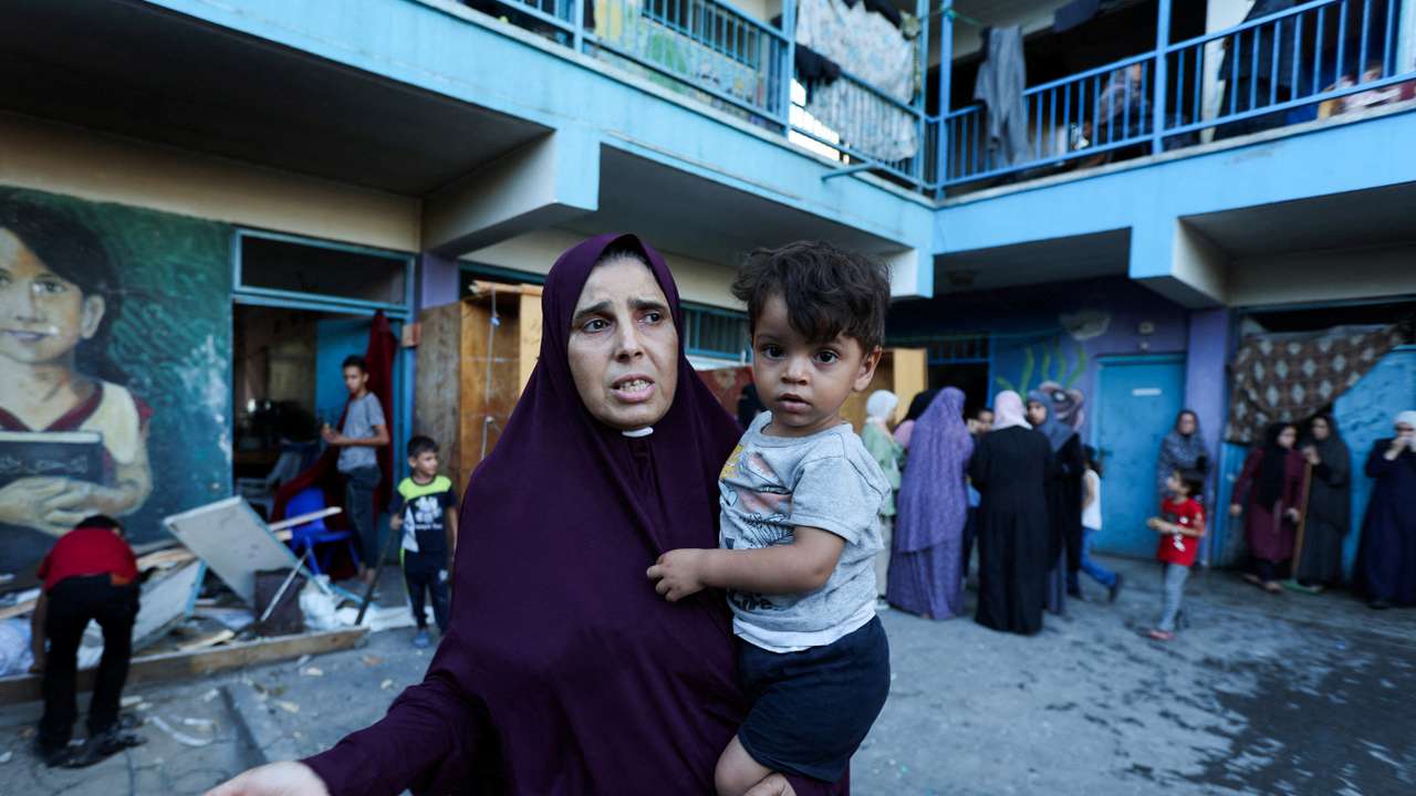 Palestinians react, after an Israeli air strike on a UN school sheltering displaced people, amid the Israel-Hamas conflict, in Nusairat