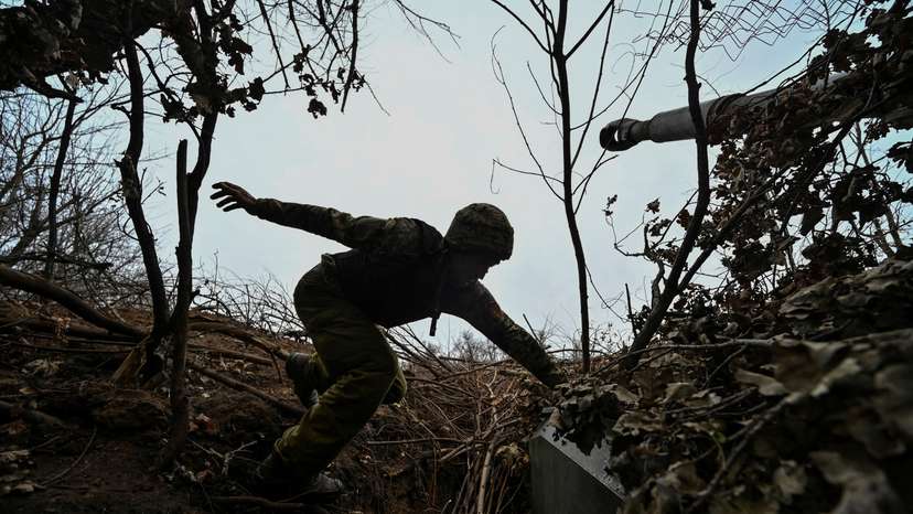Ukrainian serviceman jumps on a self-propelled howitzer at a position on a front line in Zaporizhzhia region